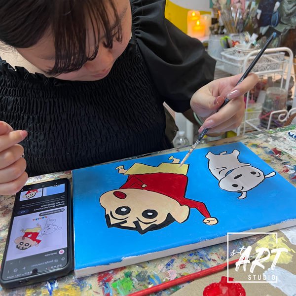 Student painting cartoon characters during Drop-In ART session