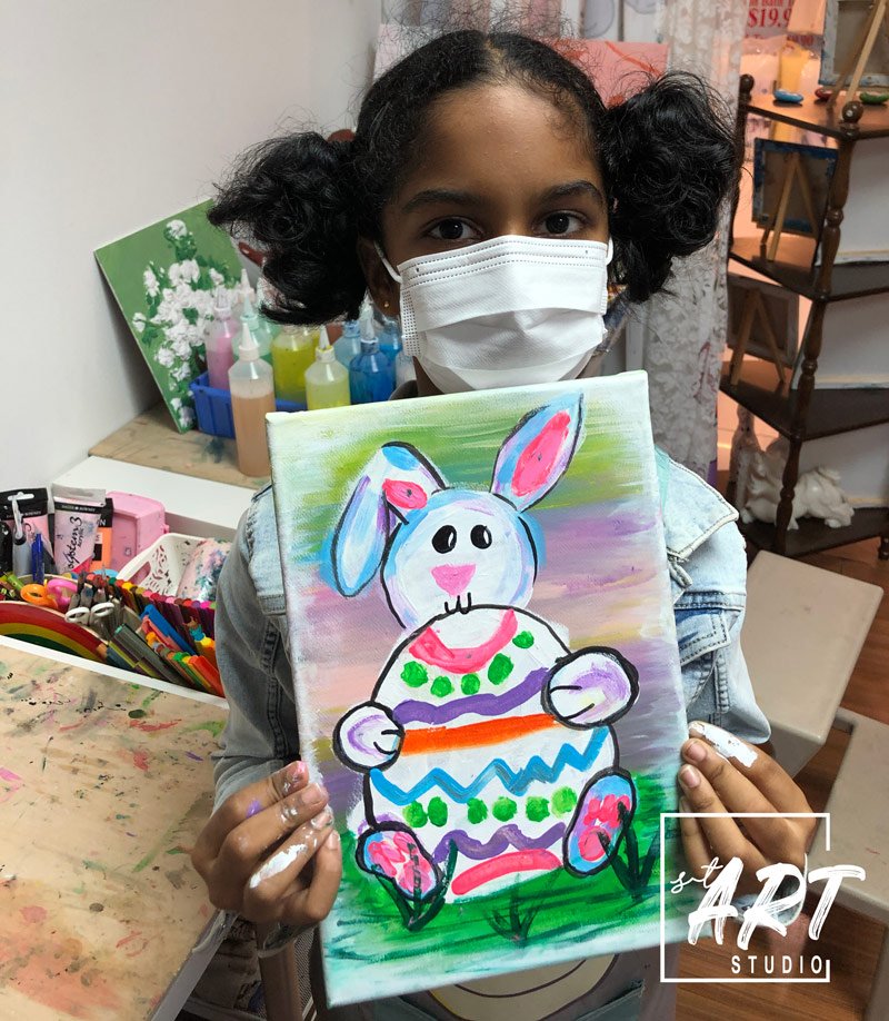 Girl proudly showing her Easter bunny painting