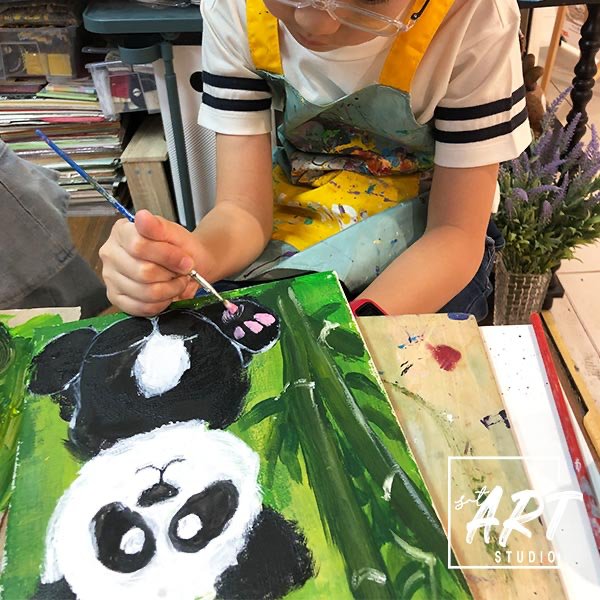 Student painting a panda at stART Studio