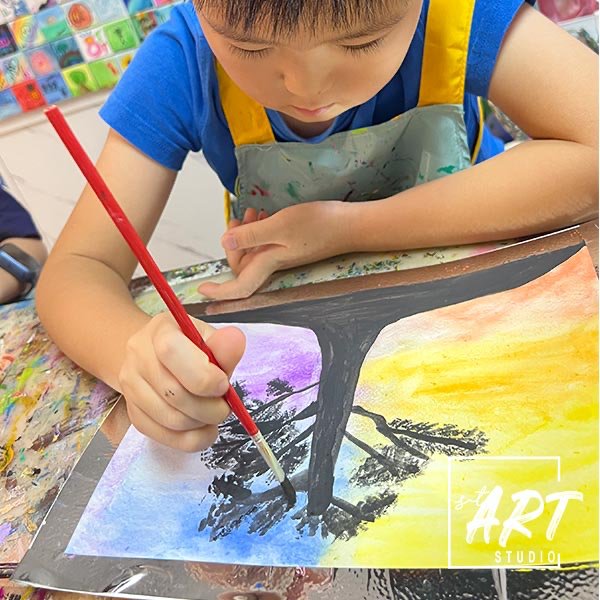 Child painting a sunset watercolour