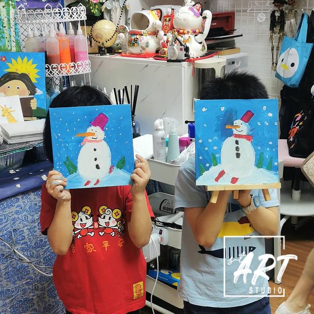 Two children with matching snowmen paintings
