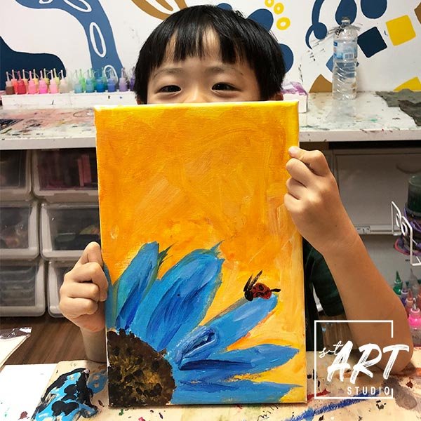 Child showing bright sunflower painting